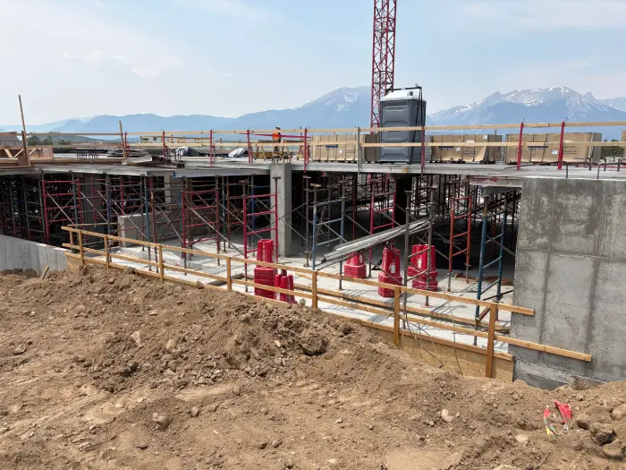 Las residencias Waterview, en construcción, con el aparcamiento y las montañas de fondo